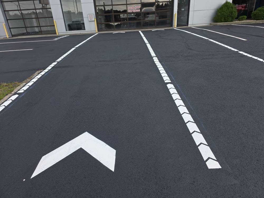 Asphalt driveway after sealcoating showing restored black finish